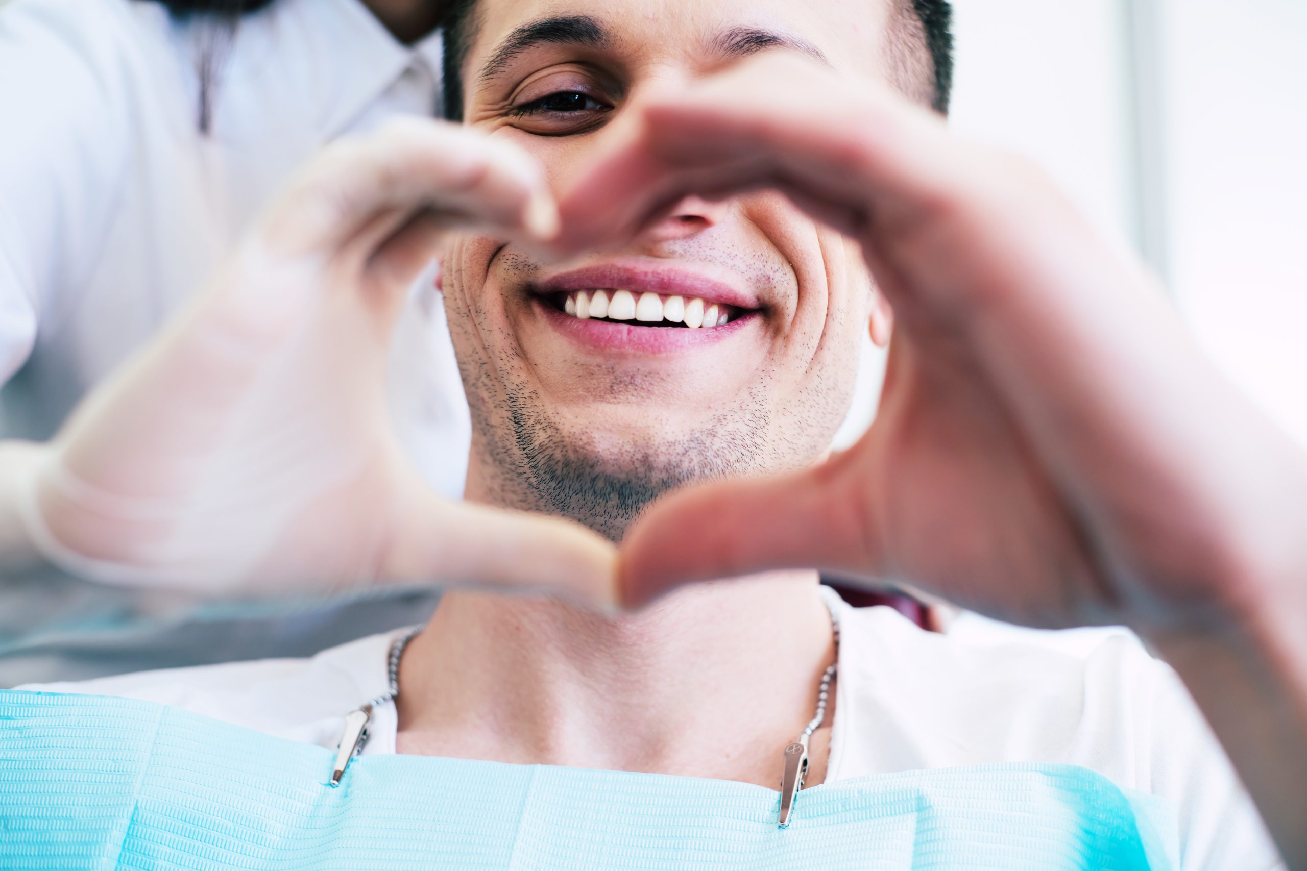 A patient with white and healthy smile in the center of a heart